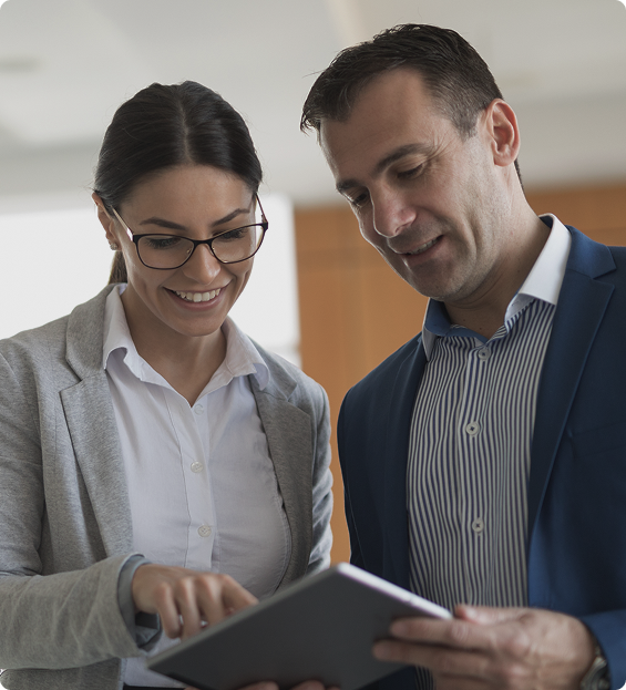 8 West Consulting - Picture of two colleagues smiling and looking at a tablet at work.