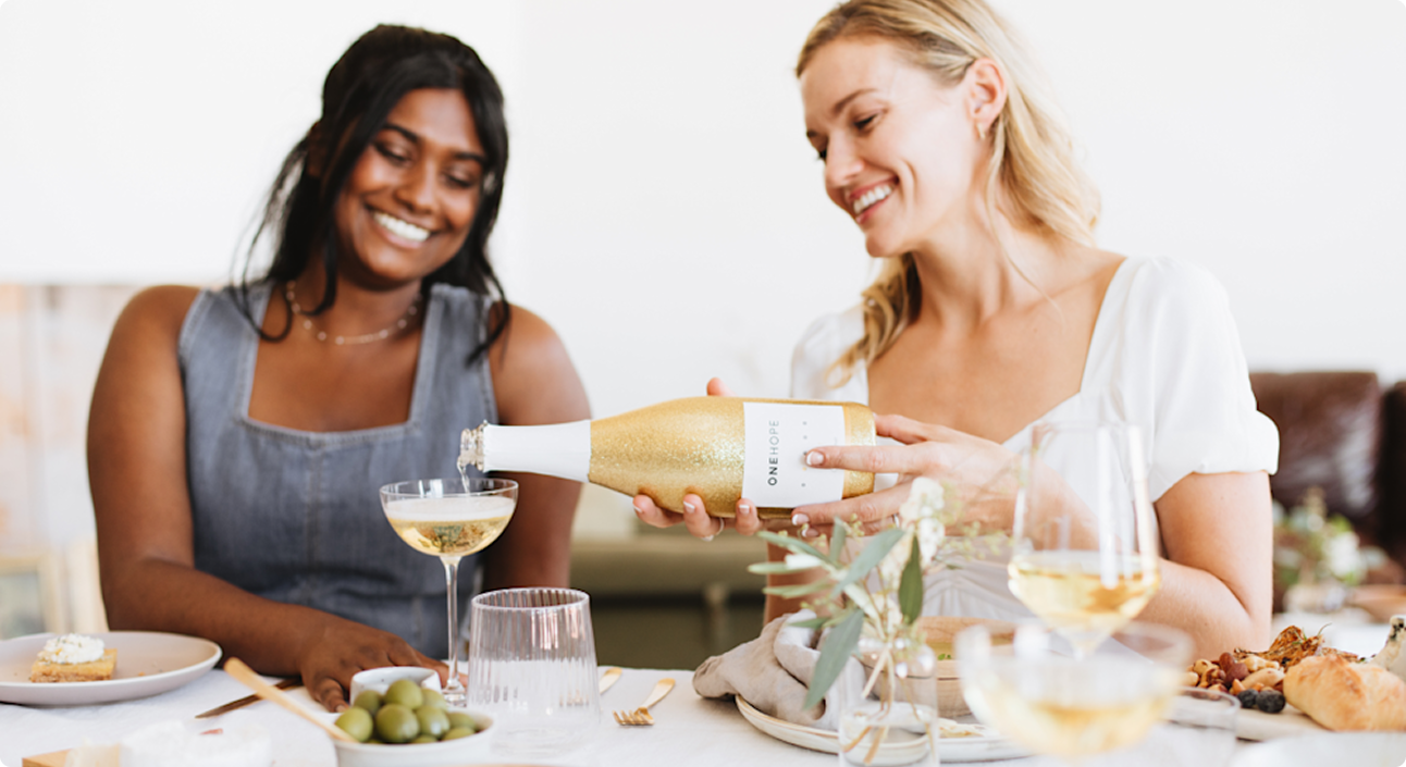 8 West Consulting website image of two girl friends enjoying OneHope bubbly wine.